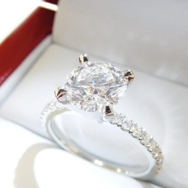 Four prong solitaire with micro pave side stones
