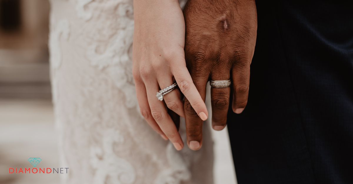 A man gently sliding a wedding ring onto a woman's right hand