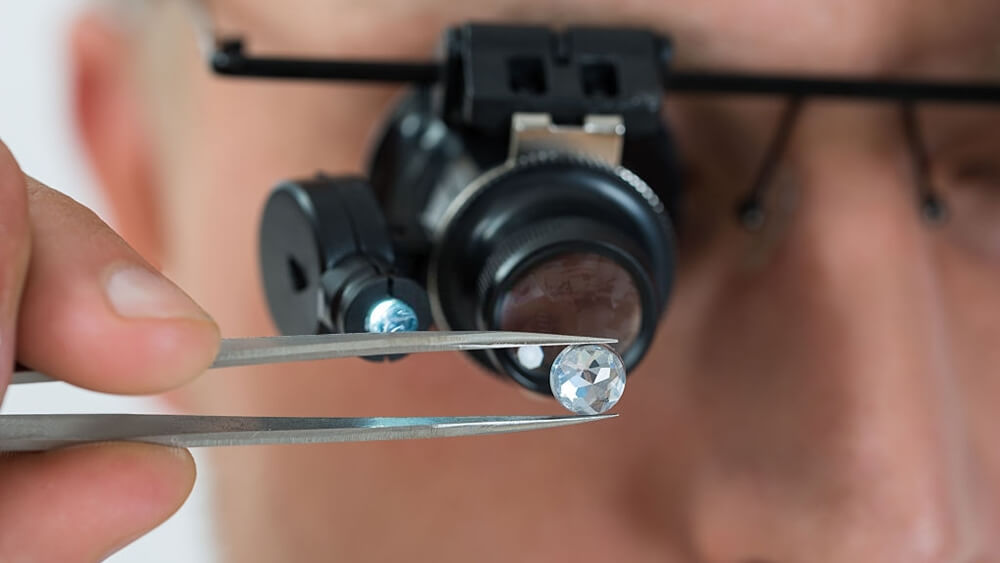 Person looking at diamond with magnifying loupe