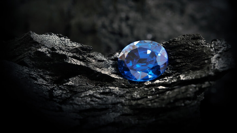 Blue sapphire on black coal background