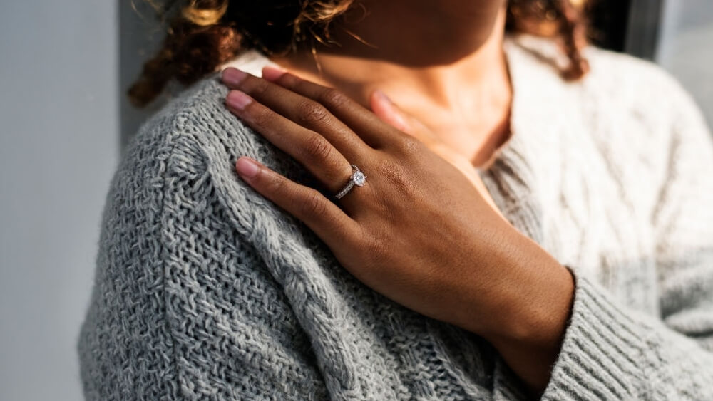 Cheerful woman wearing engagement ring with diamond