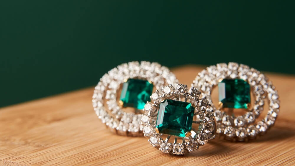 Emerald ring and pair of diamond earrings in gold