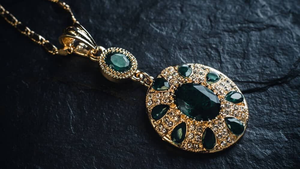 Gold pendant with green emeralds
