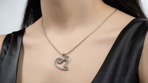 Woman with diamond and silver heart pendant on chain