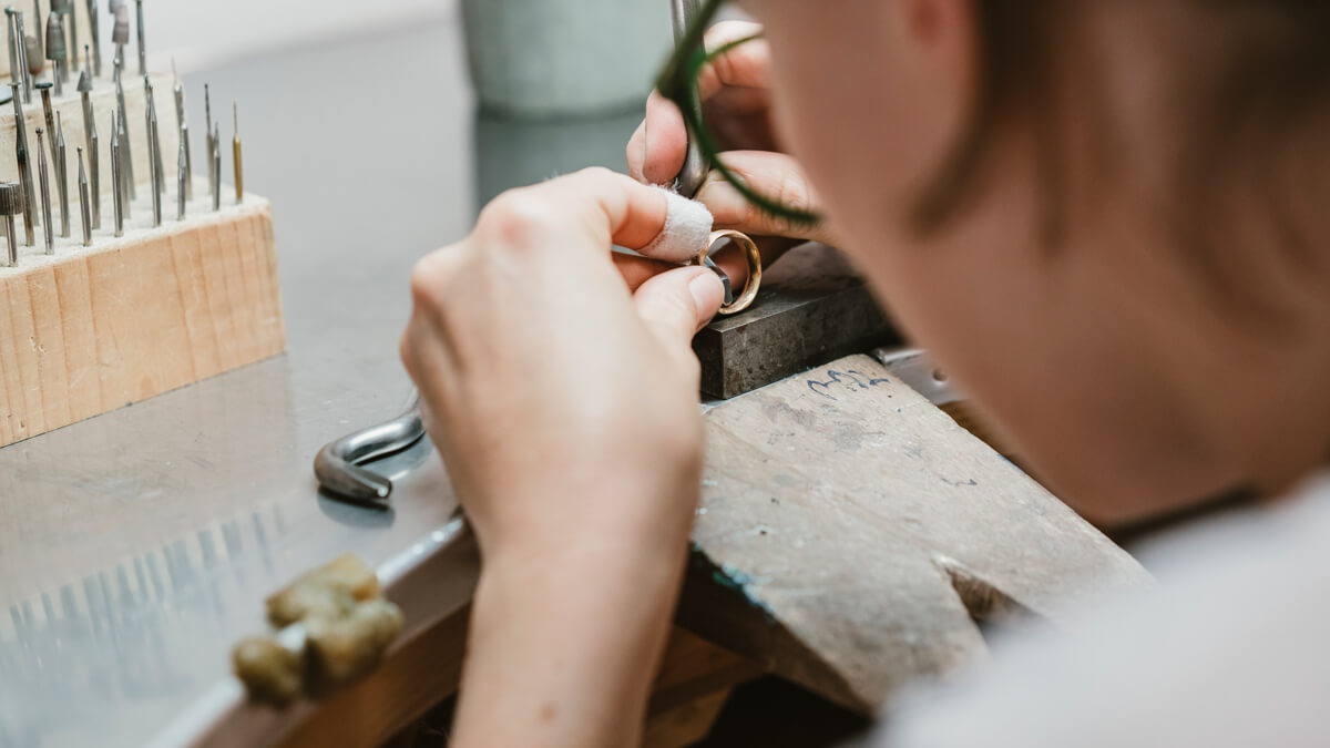 Over shoulder view of female jeweller making ring