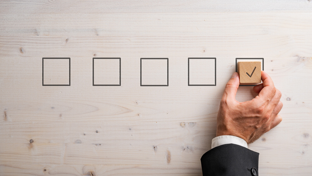 Businessman placing wooden block with a check mark