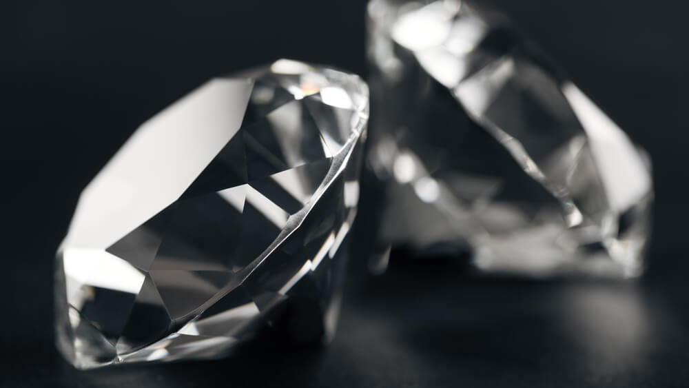 Closeup of two clear diamonds on black background