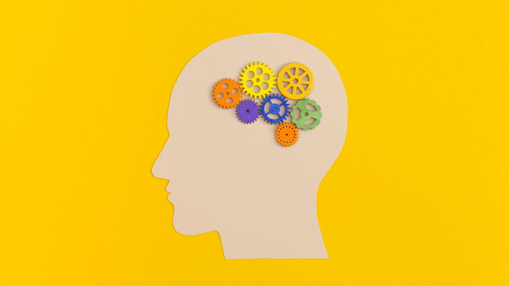 Human head with gears on yellow background