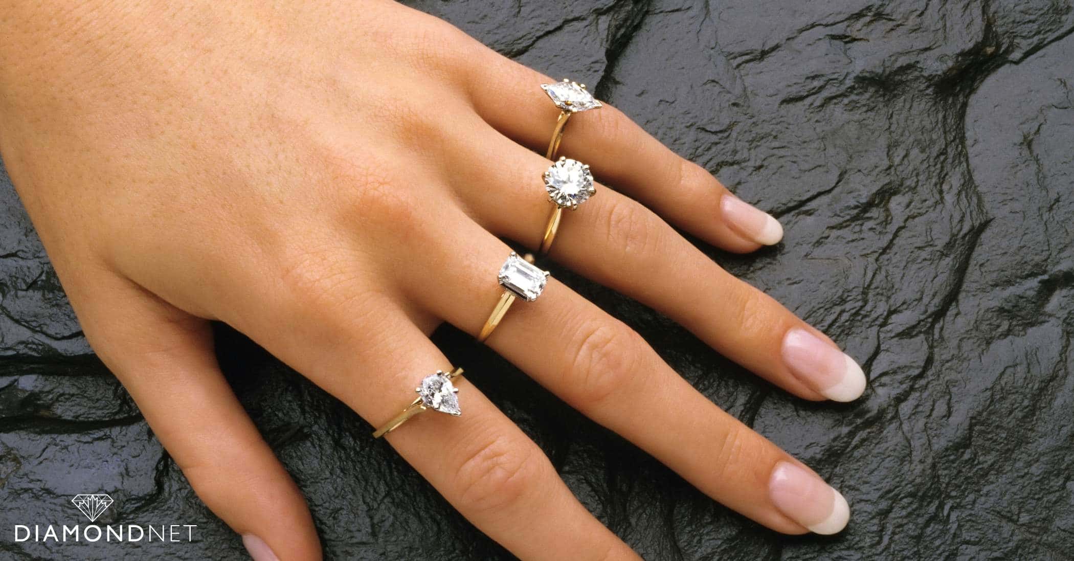 A person holds a diamond ring, symbolizing the artistry involved in designing a custom engagement ring.