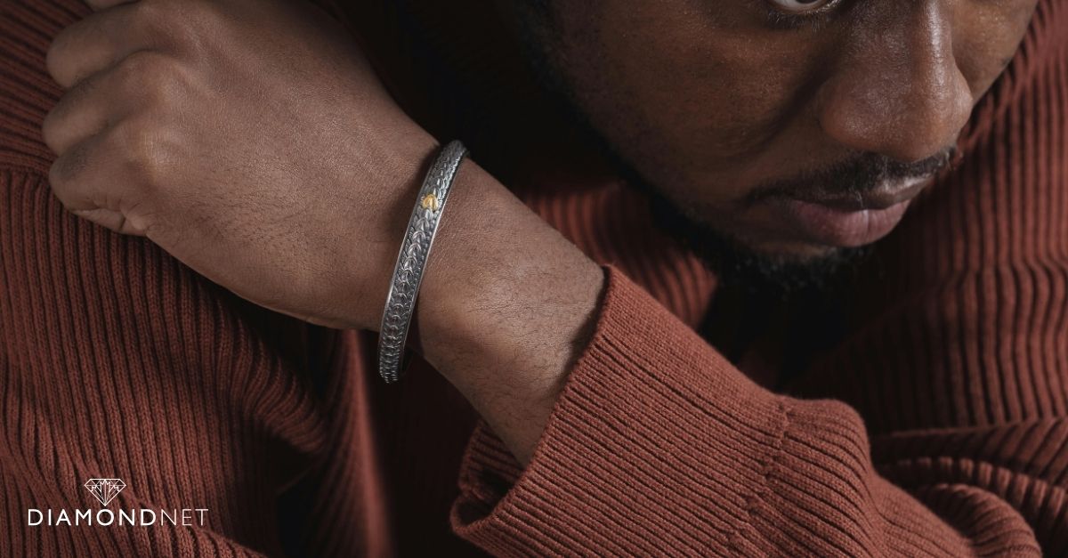 A man wearing a gold chain and rings, showcasing current men's jewellery trends.