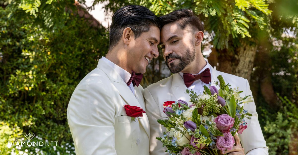 Two men stand beneath a wedding arch on the beach, showcasing a beautiful moment in an LGBTQIA+ friendly venue