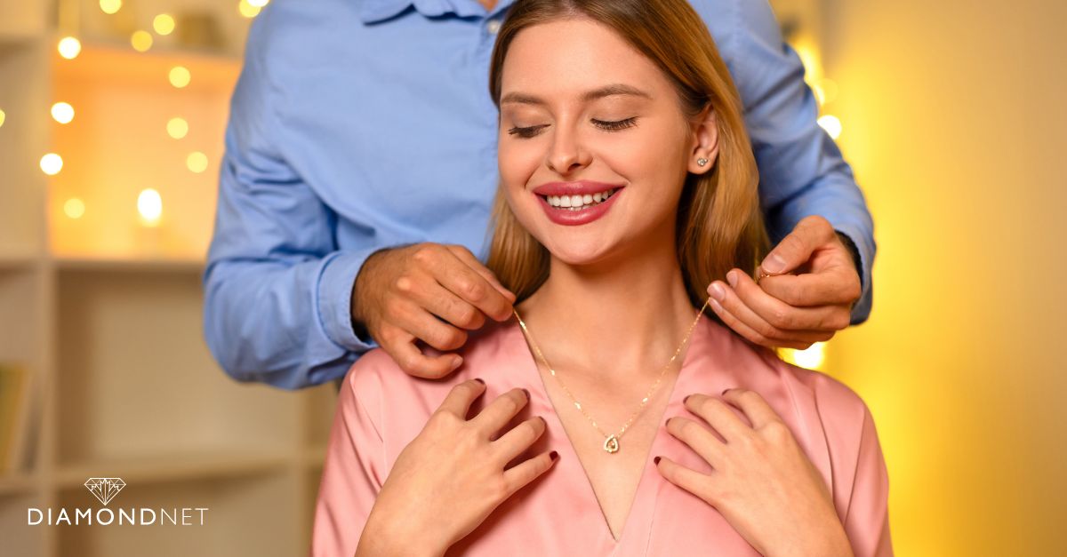 A woman beams while holding her necklace emphasizing the selection of jewellery for a Valentine's Day gift