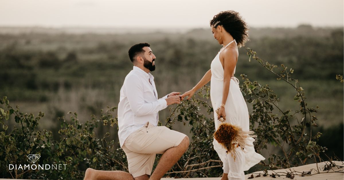 A man kneels on a balcony, proposing to a woman who looks surprised and happy, symbolizing a special proposal timing.