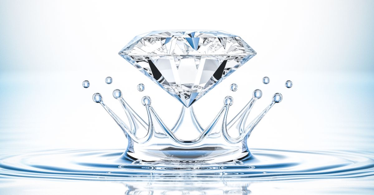 A clear glass of water with a diamond submerged, demonstrating the water test for diamond earrings