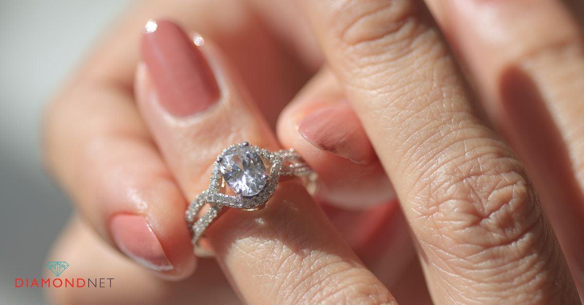 A woman's hand elegantly holds a hidden halo engagement ring, showcasing its sparkling diamonds